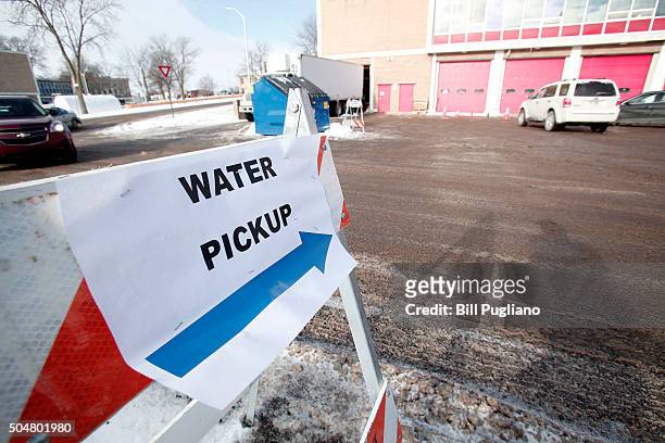 Sign points the ay for Flint residents to get bottled water, water testing kits, and water filters at a Flint Fire Station January 13, 2016 in Flint,...