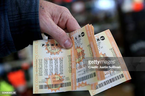 Customer holds a handful of Powerball tickets at Kavanagh Liquors on January 13, 2016 in San Lorenzo, California. Dozens of people lined up outside...
