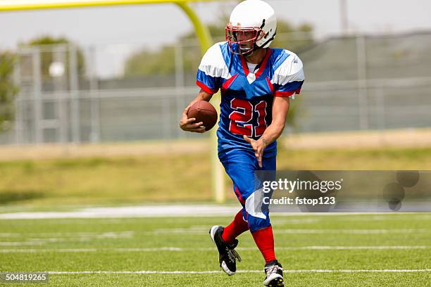 football player running with ball on playing field. goal post. - university athletics stock pictures, royalty-free photos & images