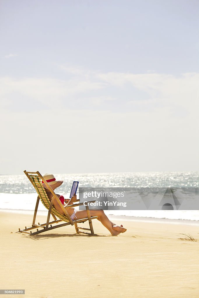 Estate vacanza sulla spiaggia leggendo con cellulare, Computer Tablet, verticale