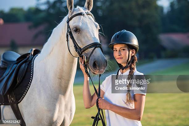 portrait of young woman standing with horse - riding hat stock pictures, royalty-free photos & images