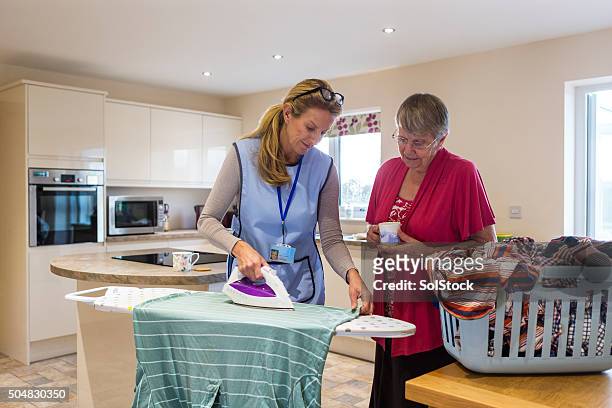 elderly care in the home - nurse helping old woman at home stock pictures, royalty-free photos & images