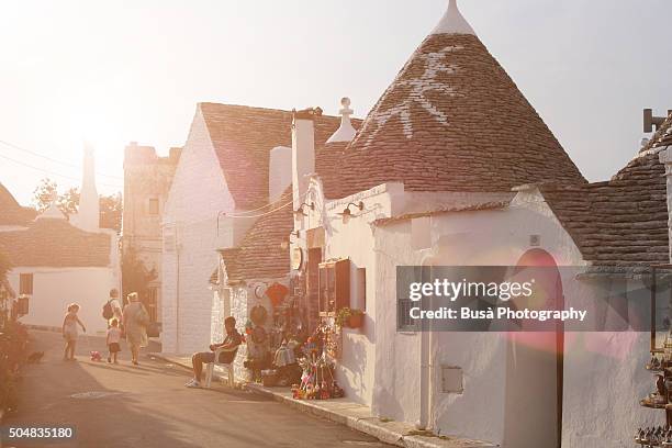 streets lined by trulli houses in alberobello, near bari, apulia, southern italy - trulli fotografías e imágenes de stock