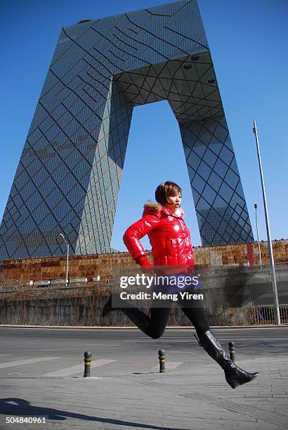 jump girl in front of the building - beijing cctv tower stock pictures, royalty-free photos & images