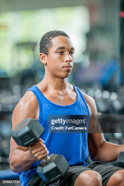 lifting dumbbells at the gym - youth weight training stock pictures, royalty-free photos & images