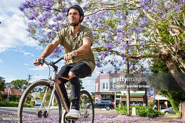 australian mid adult man riding the bike - australia street stockfoto's en -beelden