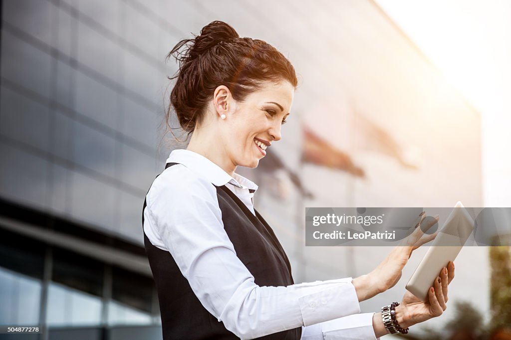 Business woman finalizing tasks on a tablet