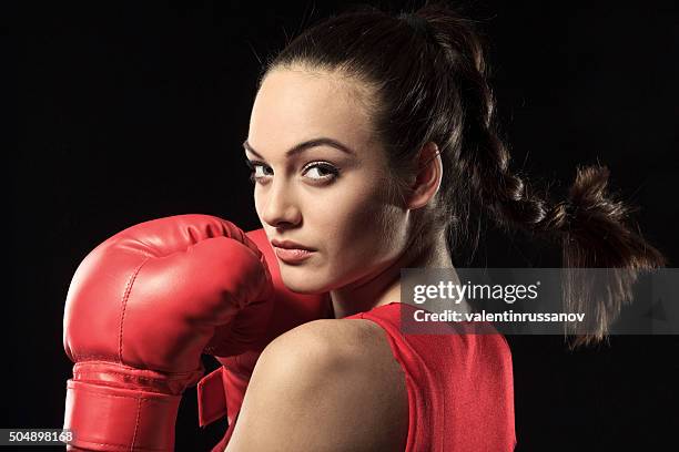 junge frau in roten boxen outfit über die schulter blicken - women's boxing stock-fotos und bilder