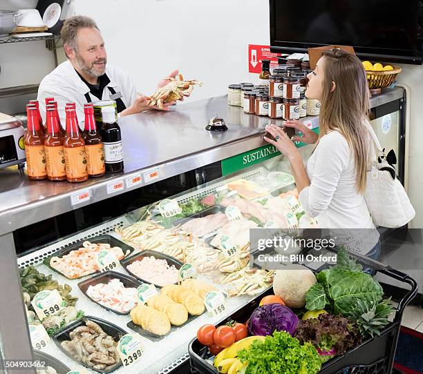 grocery shopping in meat dept. - viswinkel stockfoto's en -beelden