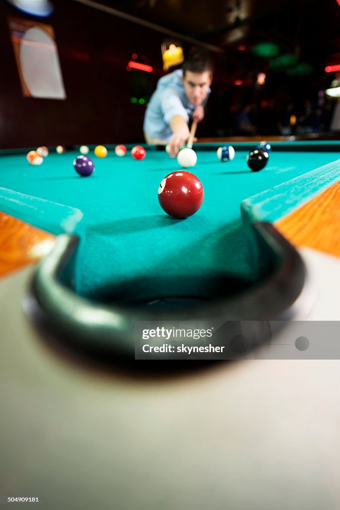Balls on a pool table with man in the background