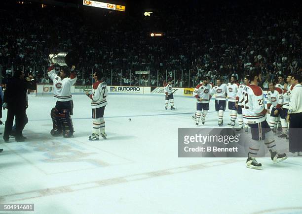Goalie Patrick Roy of the Montreal Canadiens celebrates with the Stanley Cup as teammate Guy Carbonneau looks on after Game 5 of the 1993 Stanley Cup...