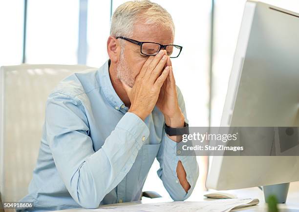 businessman looking tired in real office location - head in hands computer stock pictures, royalty-free photos & images