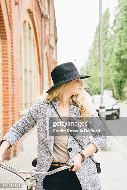 trendy young woman with her bike, city street on background - first sunny spring day in berlin stock pictures, royalty-free photos & images