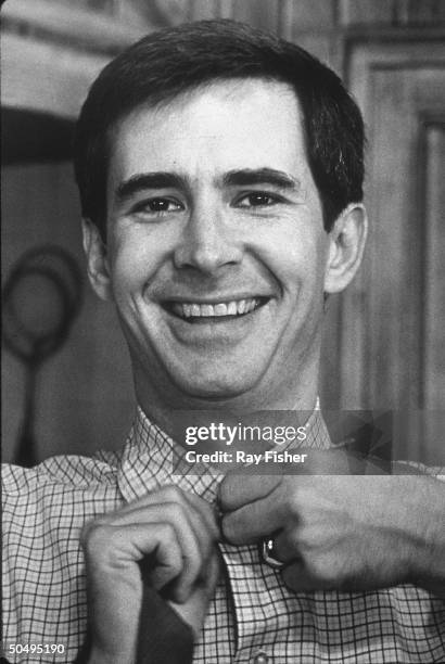 American actor Anthony Perkins buttons his shirt in a scene from a production of the Neil Simon stage play 'The Star Spangled Girl' at the Plymouth...