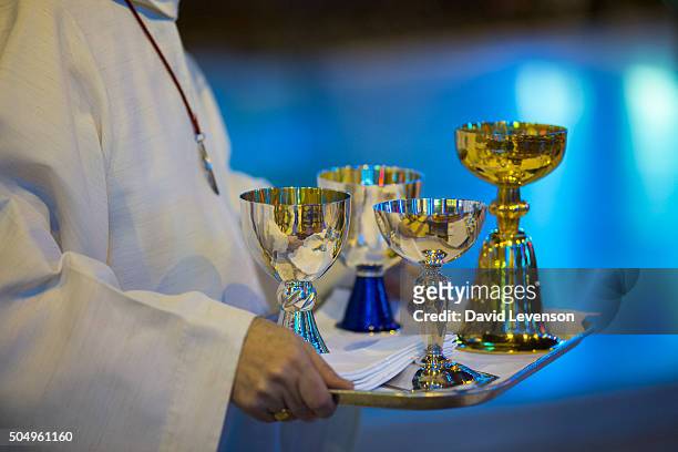In Liverpool Cathedral, an altar server carries a tray of silver goblets, to be used in Communion at the Mass on March 16, 2014 in Liverpool,...