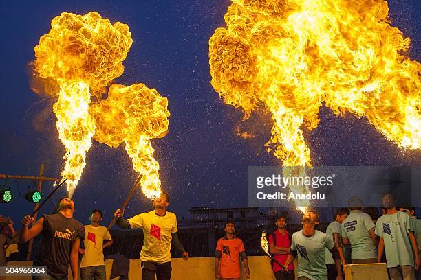 People of Old Dhaka play fire spitting using kerosene oil on the roof-top of their building on the occasion of Shakrain festival in Dhaka on January...