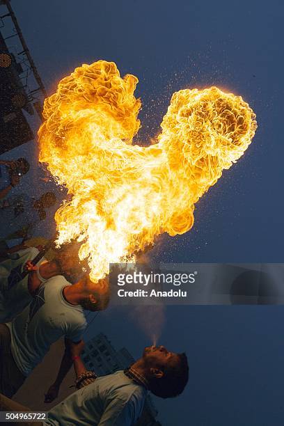People of Old Dhaka play fire spitting using kerosene oil on the roof-top of their building on the occasion of Shakrain festival in Dhaka on January...