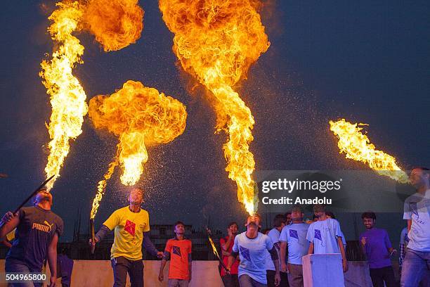 People of Old Dhaka play fire spitting using kerosene oil on the roof-top of their building on the occasion of Shakrain festival in Dhaka on January...