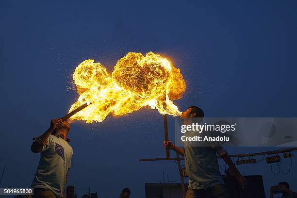 People of Old Dhaka play fire spitting using kerosene oil on the roof-top of their building on the occasion of Shakrain festival in Dhaka on January...