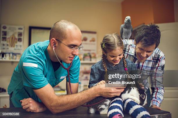 smiling family brought their rabbit to veterinarian's examination. - family rabbit stock pictures, royalty-free photos & images