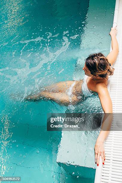 mujer sana ofrece día relajante en centro spa en traje de baño - balneario fotografías e imágenes de stock