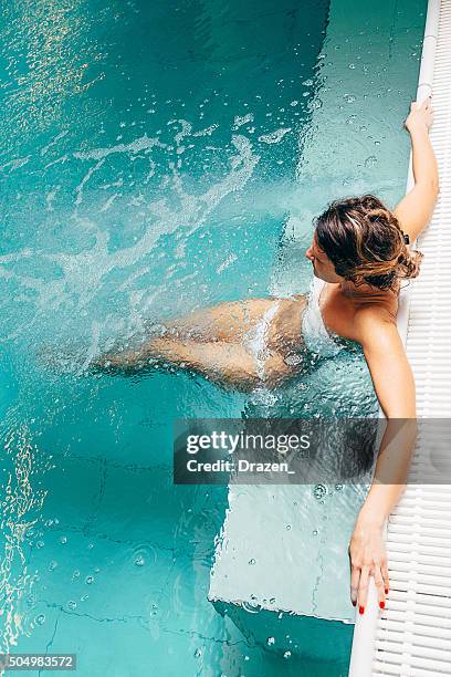 healthy woman enjoys relaxing day at spa centre in swimsuit - hälsosalong bildbanksfoton och bilder