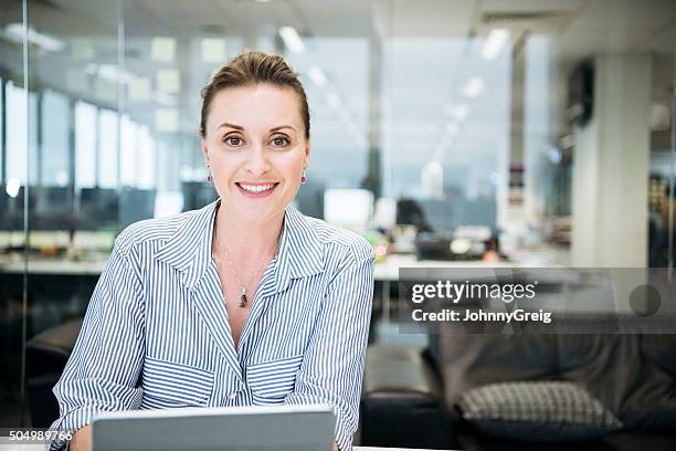 portrait of mid adult caucasian businesswoman smiling towards camera - woman 30s stock pictures, royalty-free photos & images