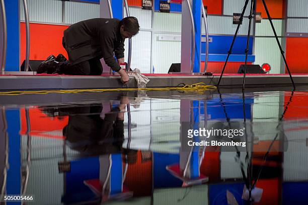 Worker prepares the stage ahead of the Republican presidential candidate debate at the North Charleston Coliseum and Performing Arts Center in North...
