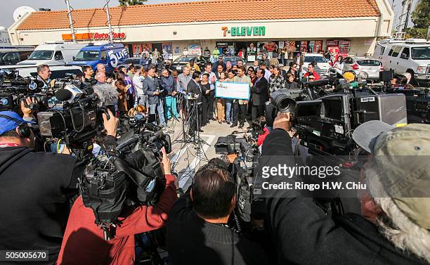 Media look on as Balbir Atwal, owner of the California 7-Eleven that sold one of the 3 Powerball winning tickets, receives a $1 million check from...