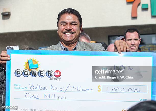 Balbir Atwal, owner of the California 7-Eleven that sold one of the 3 Powerball winning tickets, holds up a $1 million check after received from the...