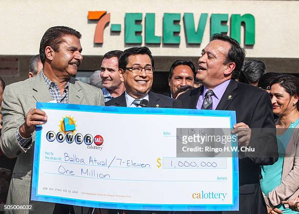 California State Lottery spokesperson Russ Lopez, center, looks on as Balbir Atwal, left, owner of the California 7-Eleven that sold one of the 3...