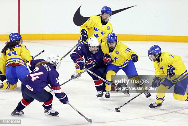 Natalie Snodgrass of Team USA and Ida Nikola of Team Sweden battle for position as Linnea Andersson skates with the puck in a semifinal game during...