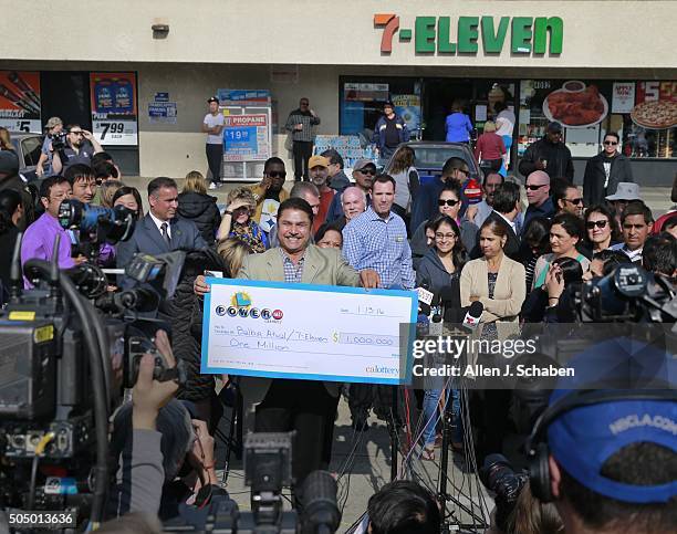 Chino Hills 7-Eleven franchise owner Balbir Atwal, of Yorba Linda, and originally from Punjab, India, holds his $1 million check Powerball during a...