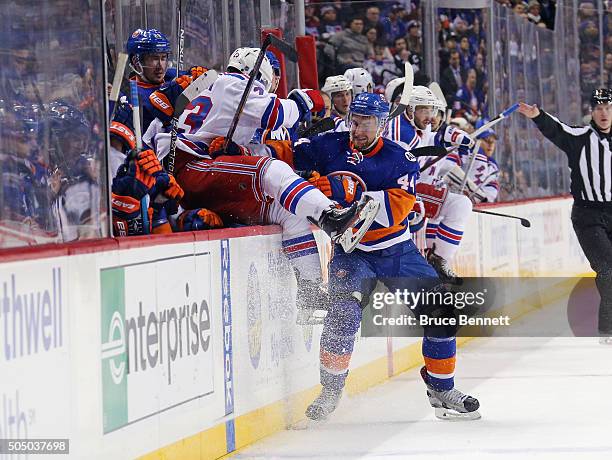 Calvin de Haan of the New York Islanders checks Jayson Megna of the New York Rangers into the Islander bench during the third period at the Barclays...