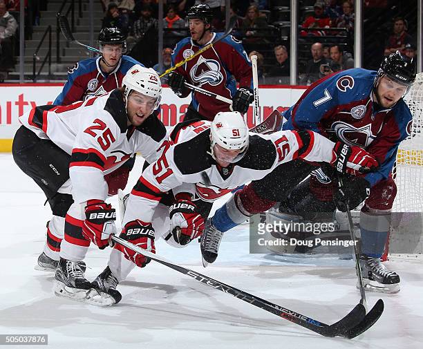 John Mitchell of the Colorado Avalanche clears the puck away from Stefan Matteau and Sergey Kalinin of the New Jersey Devils at Pepsi Center on...