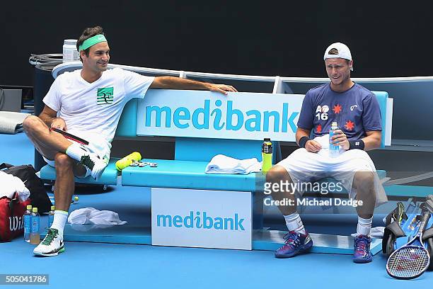 Roger Federer of Switzerland talks with Lleyton Hewitt of Australia during a practice session ahead of the 2016 Australian Open at Melbourne Park on...