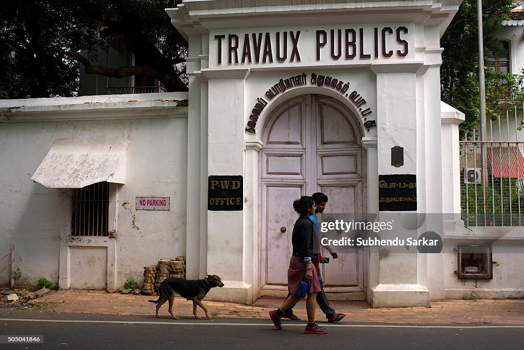 A couple walks past a French colonial building in Puducherry...