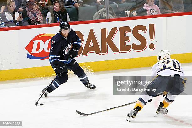 Matt Halischuk of the Winnipeg Jets plays the puck as Paul Gaustad of the Nashville Predators defends during second period action at the MTS Centre...