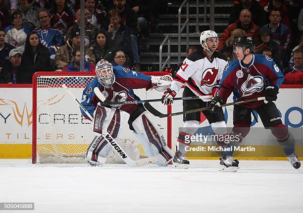 Goaltender Calvin Pickard of the Colorado Avalanche looks around teammate Chris Wagner and Kyle Palmieri of the New Jersey Devils at the Pepsi Center...