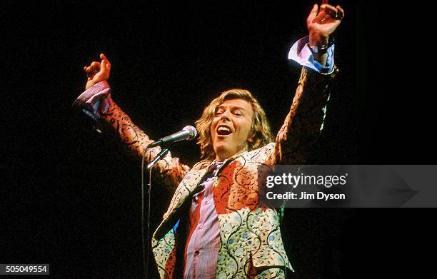 David Bowie performs live on the Pyramid stage wearing a coat designed by Alexander McQueen, at the Glastonbury festival at Worthy Farm on June 25,...