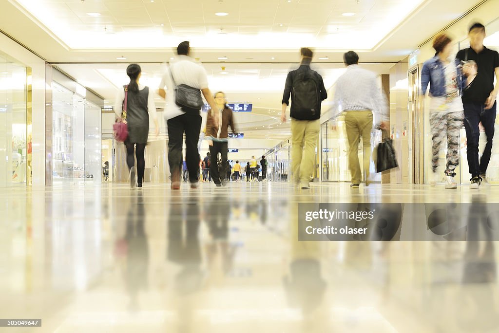 Motion blurred customers walking in shopping mall, Hong Kong