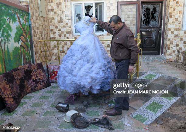 Ahmed Hassan Majid, a Shiite Turkmen, holds the only wedding dress which survived the torching of his house and bridal shop during a wave of...