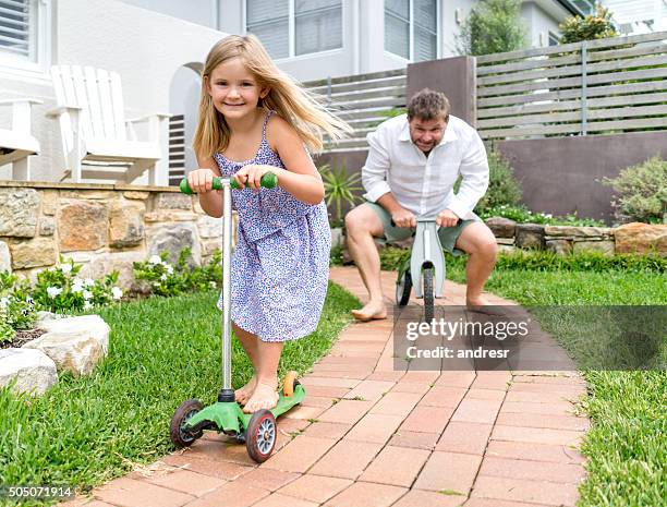 father and daughter playing together - tricycle stock pictures, royalty-free photos & images