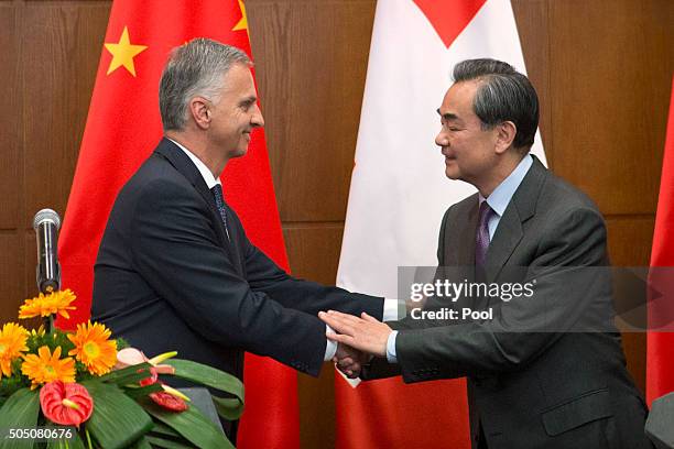 Swiss Foreign Minister Didier Burkhalter, left, shakes hands with Chinese Foreign Minister Wang Yi, right, after a joint press conference at the...