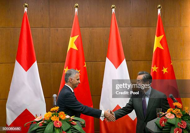 Swiss Foreign Minister Didier Burkhalter, left, shakes hands with Chinese Foreign Minister Wang Yi, right, after a joint press conference at the...