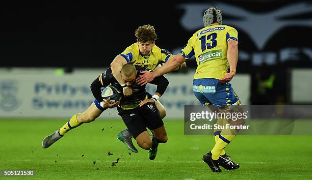 Ospreys wing Eli Walker is tackled by David Strettle and Jonathan Davies of Clermont during the European Rugby Champions Cup Pool 2 match between...