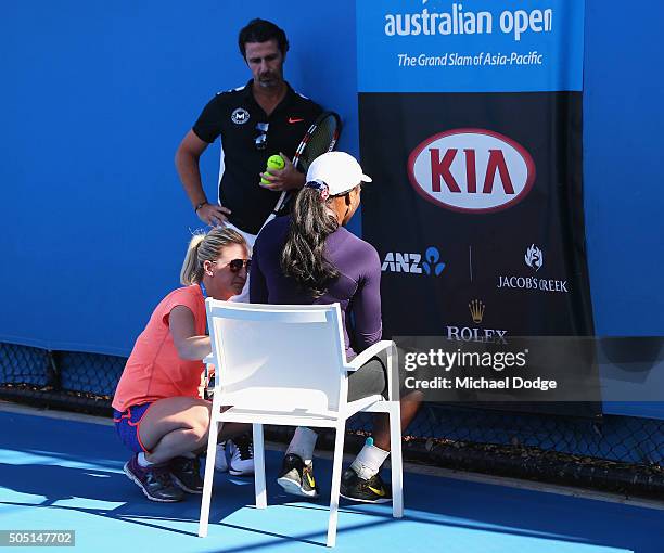 Serena Williams of the USA gets a physiotherapist to treat her next to coach Patrick Mouratoglou during a practice session ahead of the 2016...