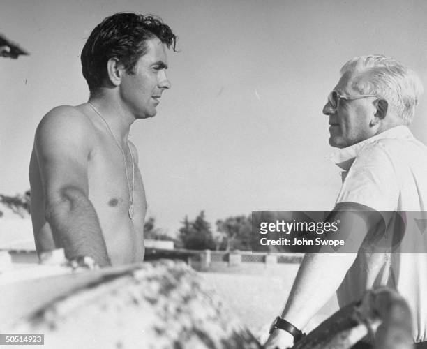 Actor Tyrone Power chatting with director Anatole Litvak while vacationing on French Riviera.