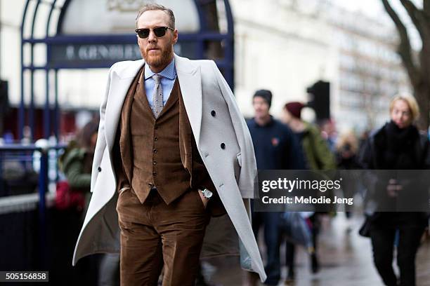 Stylist Joe Ottaway wears a Ray-Ban sunglasses, a white Reiss peacoat over the shoulders, Massimo Dutti made-to-measure bespoke suit, waistcoat, and...