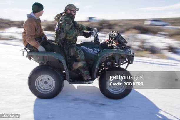 Armed federal building occupiers Corey Lequieu and Geoff Stank , both with AR15 rifles, ride a four wheeler at the Malheur National Wildlife Refuge...